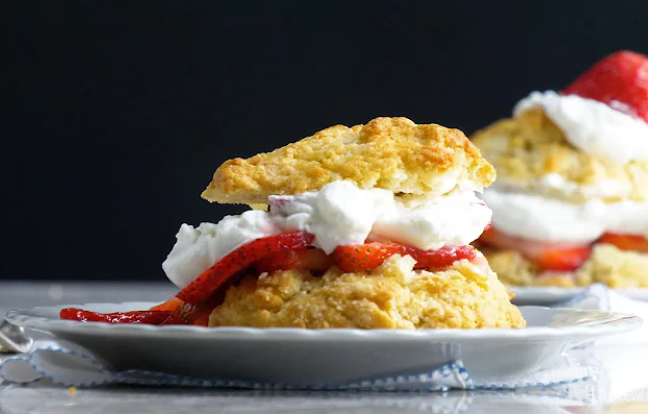 Homemade old-fashioned strawberry shortcake with whipped cream topped with fresh strawberries